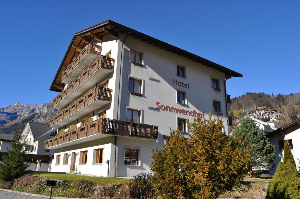 a large white building with a balcony at Hotel Sonnwendhof Engelberg in Engelberg