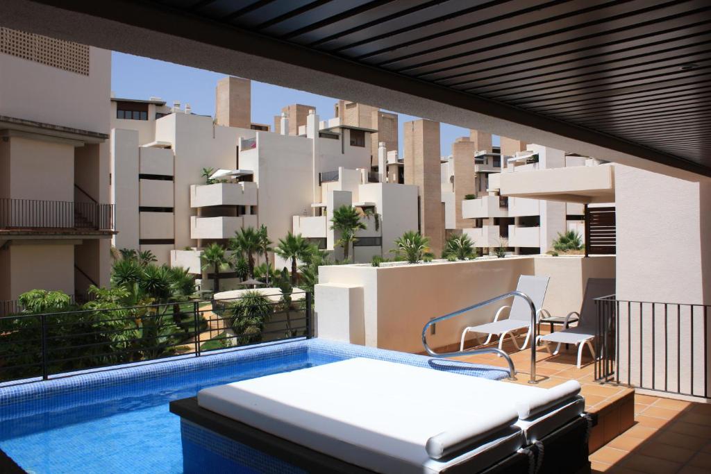 a balcony with a bed and a view of a building at 104 - Apartment with private swimming pool in Estepona