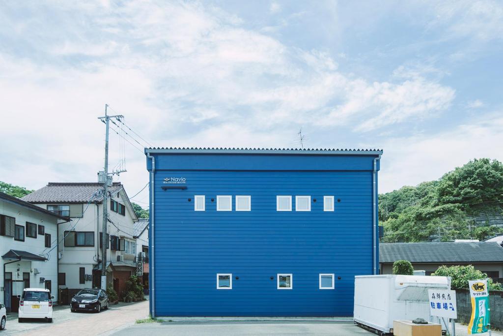 Kami Amakusa的住宿－Seacruise House Navio，一座蓝色的大建筑,其一侧设有窗户