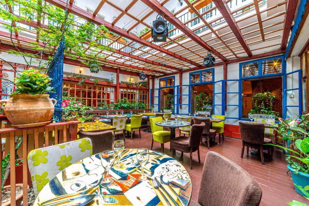 um restaurante com mesas e cadeiras e um tecto de vidro em Hotel Salvator em Praga
