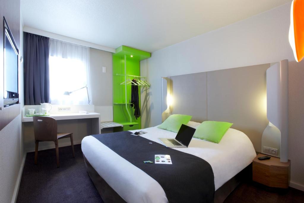 een hotelkamer met een bed met een laptop erop bij Campanile Lyon Ouest Tassin in Tassin-la-Demi-Lune