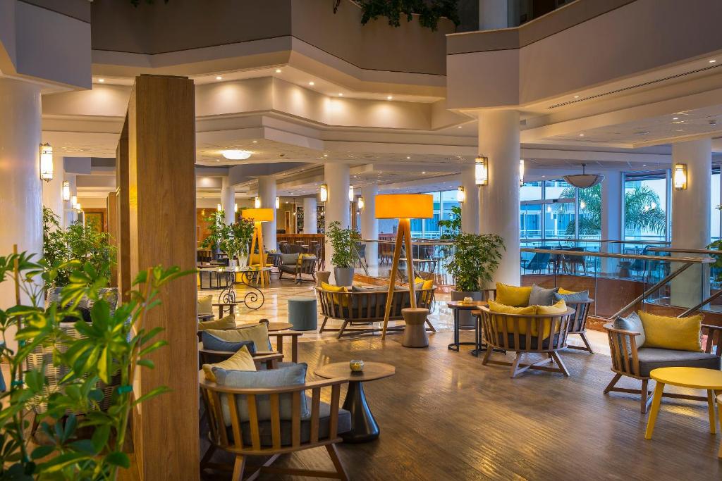 a lobby of a hotel with tables and chairs at Leonardo Cypria Bay in Paphos
