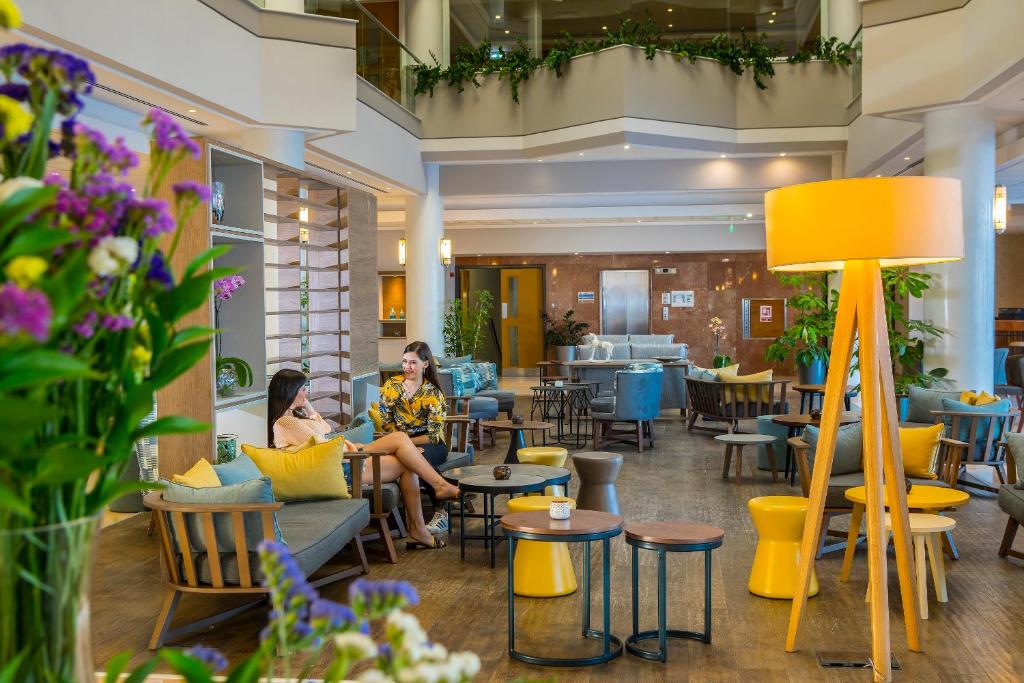 two women sitting in the lobby of a restaurant at Leonardo Cypria Bay in Paphos