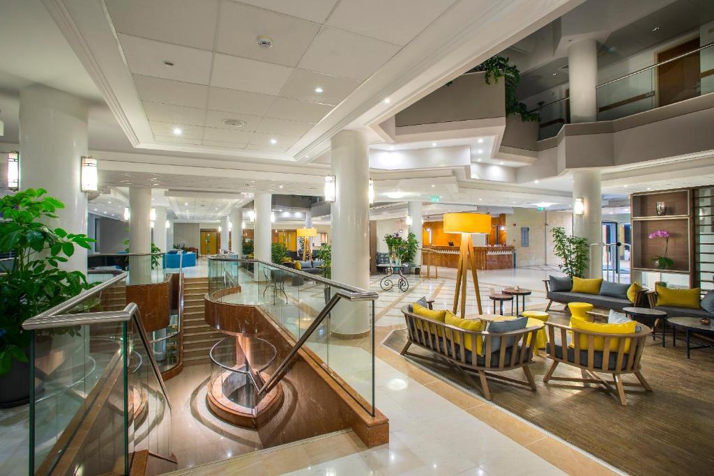 a lobby with chairs and tables in a building at Leonardo Cypria Bay in Paphos