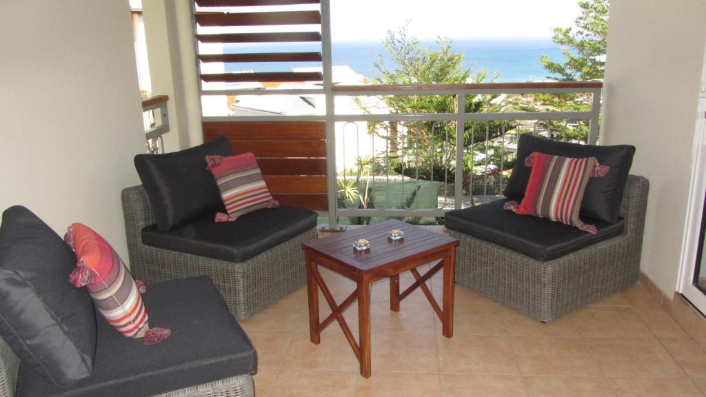 uma sala de estar com duas cadeiras e uma mesa em Aurore Réunion em Saint-Gilles-les-Bains