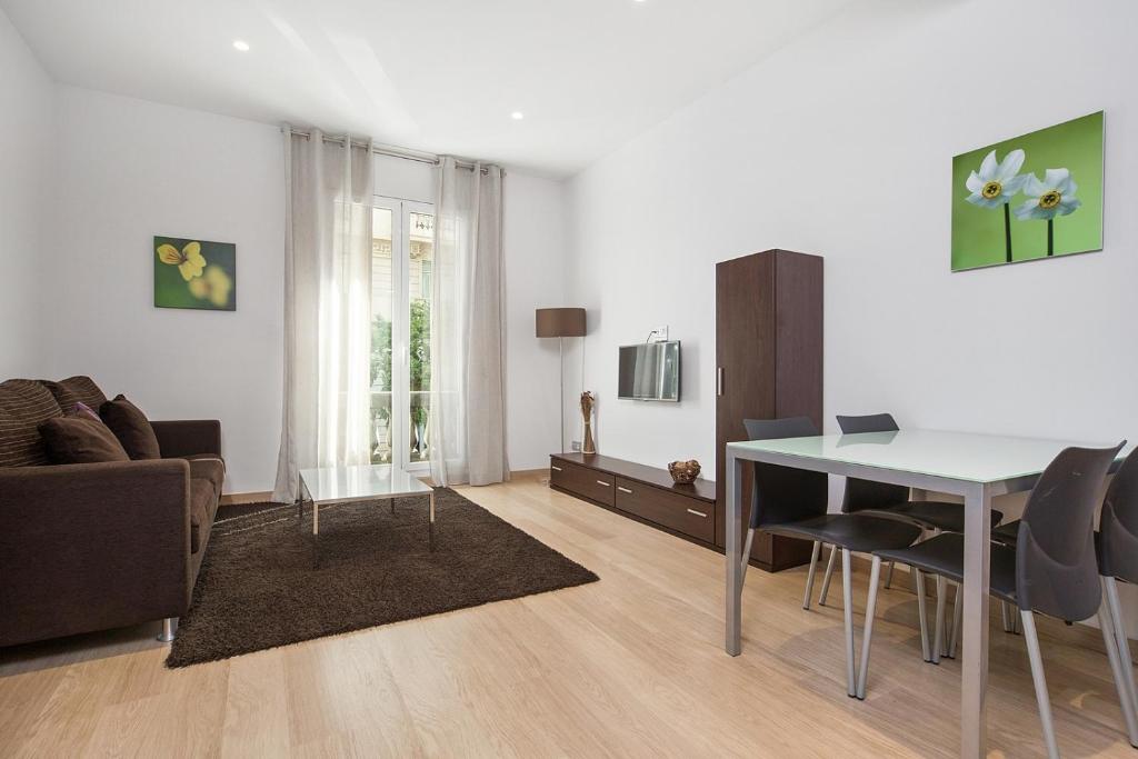 a living room filled with furniture and a table at Fisa Rentals Gran Via Apartments in Barcelona