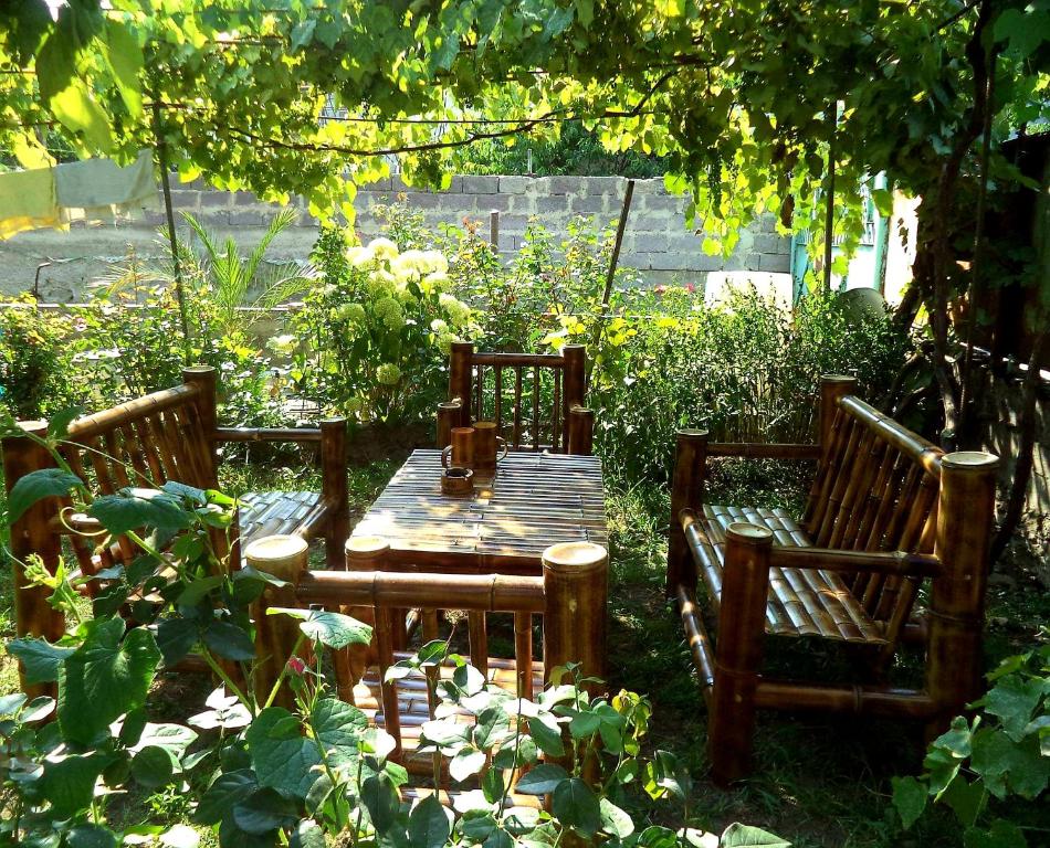 a wooden table and chairs in a garden at Guest House Metreveli in Borjomi