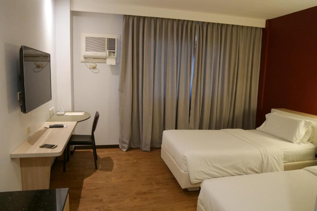 Postel nebo postele na pokoji v ubytování Circle Inn Hotel and Suites Bacolod