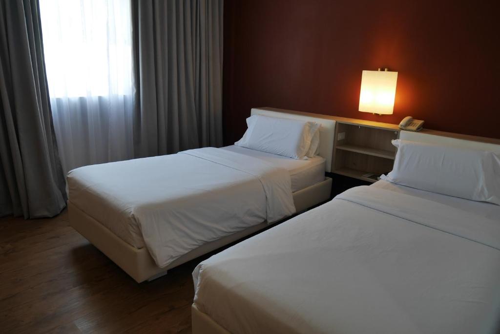 Postel nebo postele na pokoji v ubytování Circle Inn Hotel and Suites Bacolod