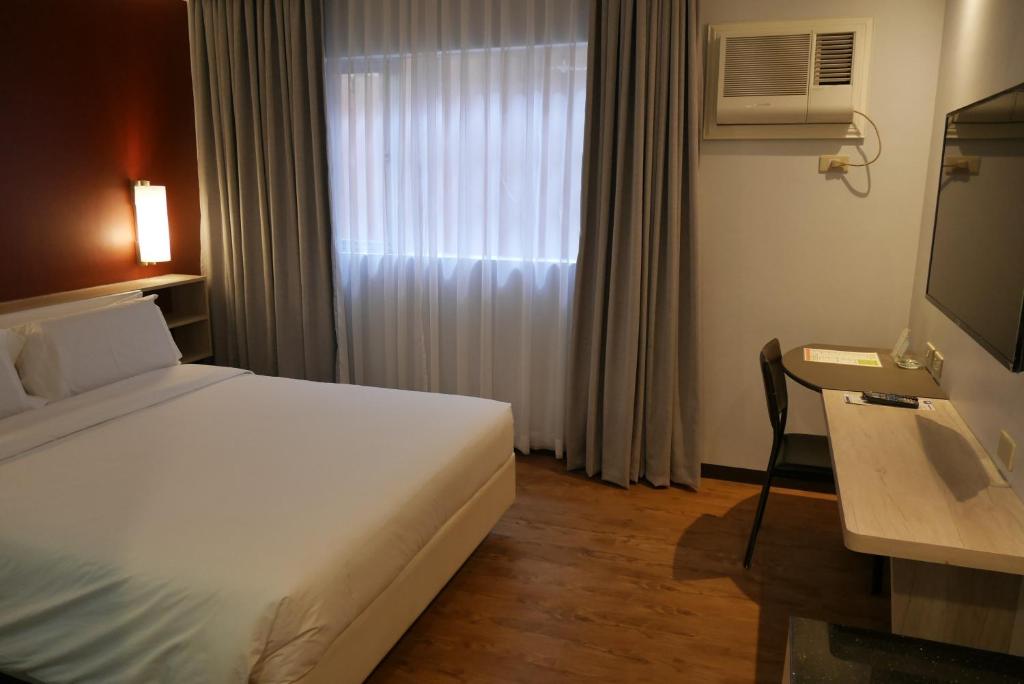 Postel nebo postele na pokoji v ubytování Circle Inn Hotel and Suites Bacolod