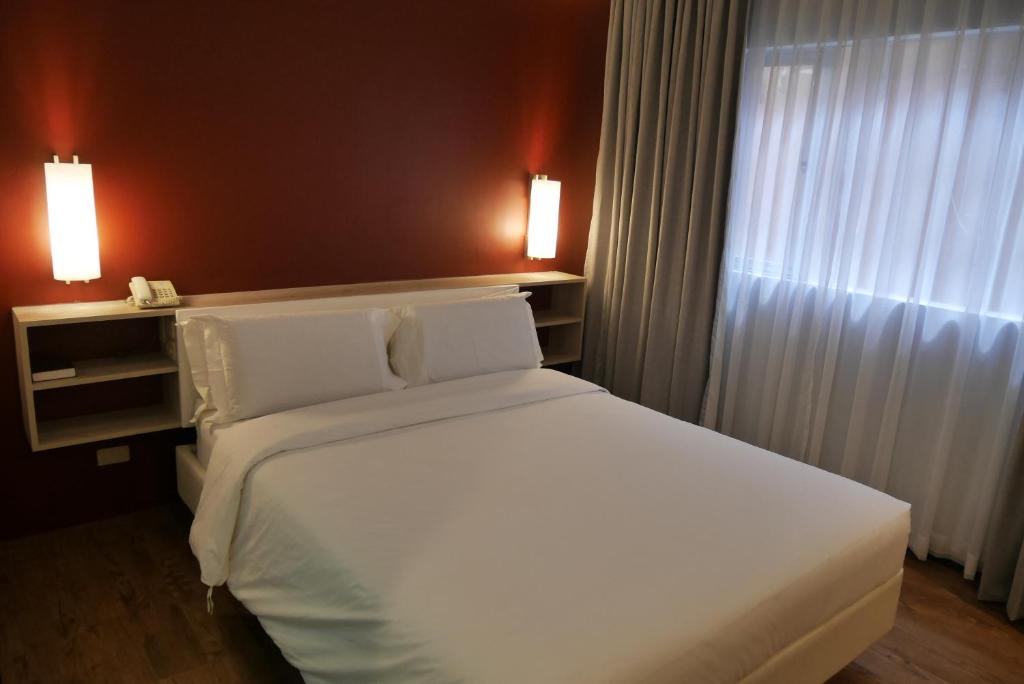 Postel nebo postele na pokoji v ubytování Circle Inn Hotel and Suites Bacolod