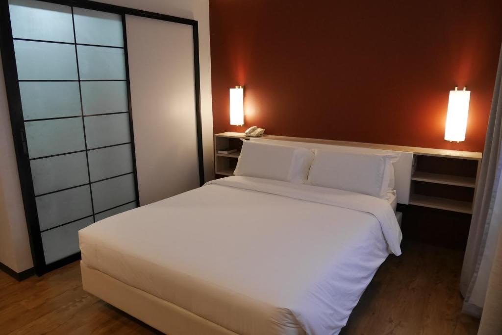 Postel nebo postele na pokoji v ubytování Circle Inn Hotel and Suites Bacolod