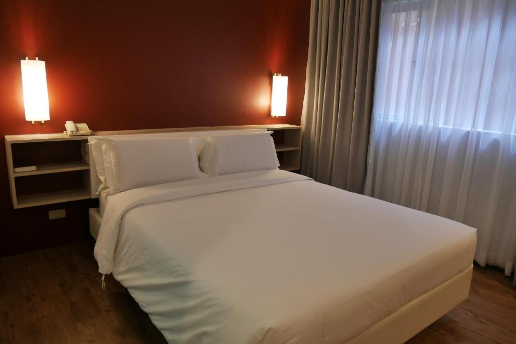 Postel nebo postele na pokoji v ubytování Circle Inn Hotel and Suites Bacolod