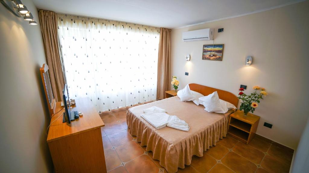 a bedroom with a bed and a large window at Vila Argentinia (Aria Betul) in Saturn