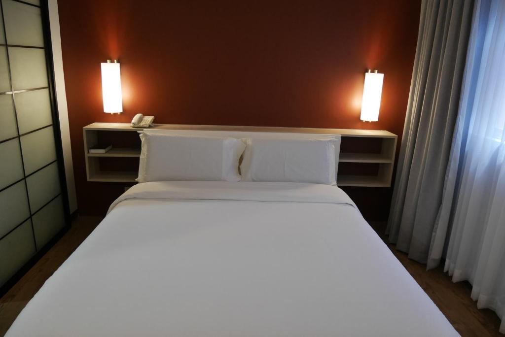 Postel nebo postele na pokoji v ubytování Circle Inn Hotel and Suites Bacolod