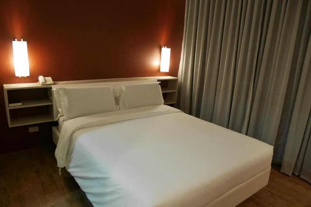 Postel nebo postele na pokoji v ubytování Circle Inn Hotel and Suites Bacolod