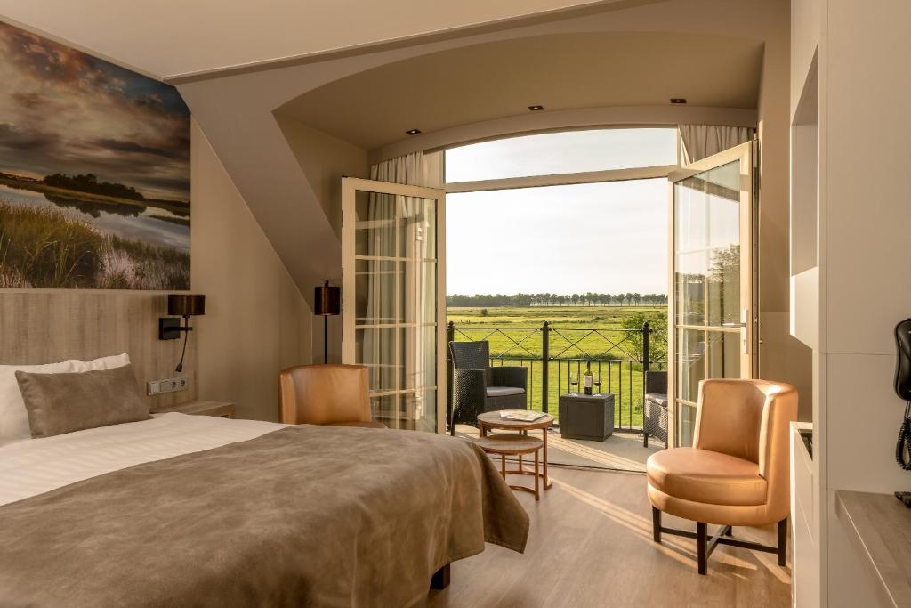 a bedroom with a bed and a balcony with a view at Van der Valk Hotel Groningen-Westerbroek in Westerbroek