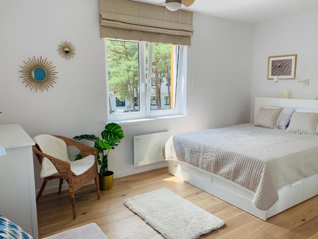een witte slaapkamer met een bed en een raam bij Hilltom by the Sea in Rowy