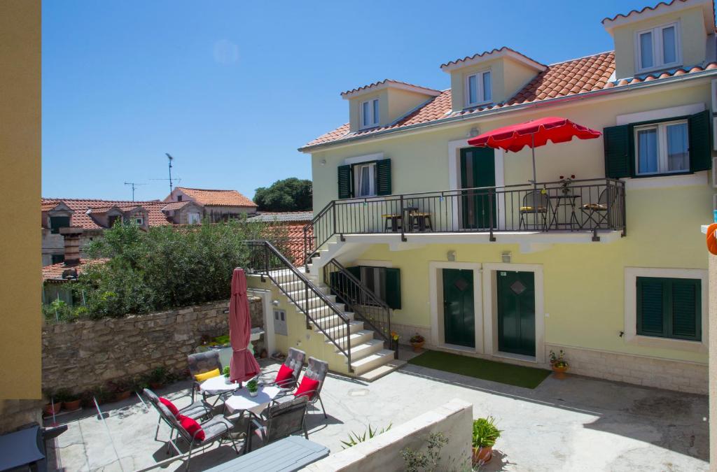 Cette maison dispose d'une terrasse avec des chaises et un parasol. dans l'établissement Central Old Town Rooms, à Split