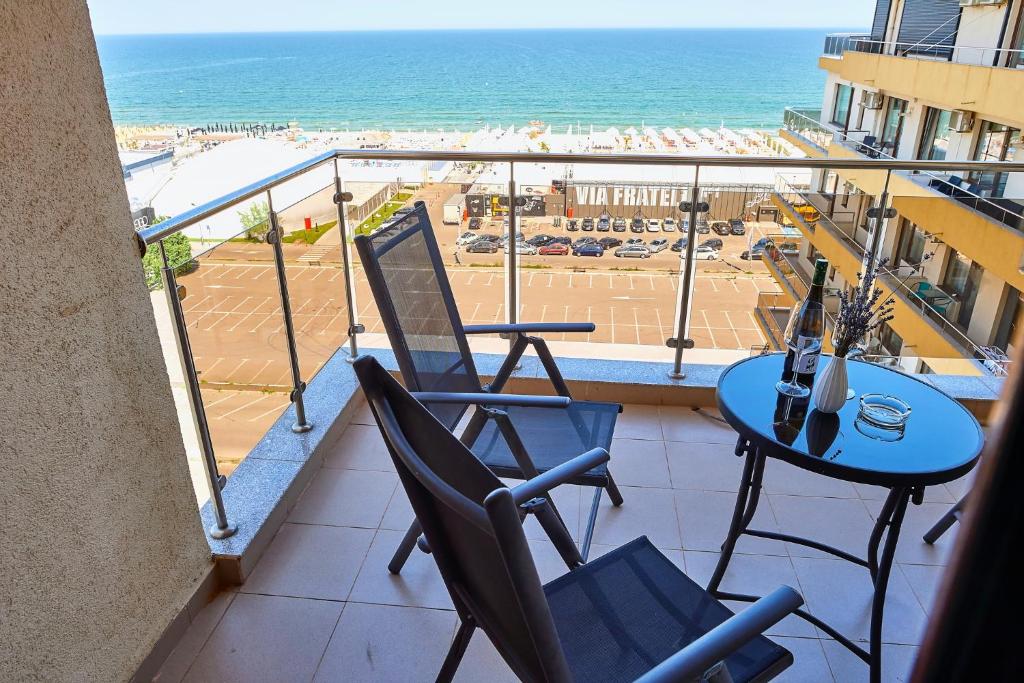 uma varanda com mesa e cadeiras e a praia em Apartament Summerland vedere la mare em Mamaia