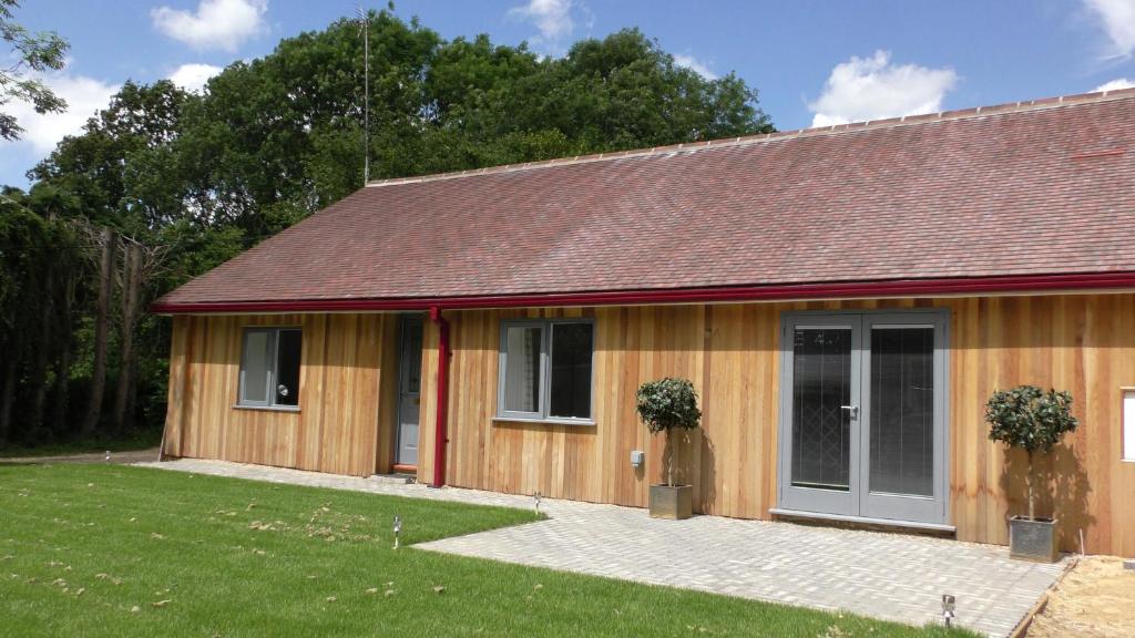 a wooden house with a porch and a yard at The Lodge Greatwood in Ipswich