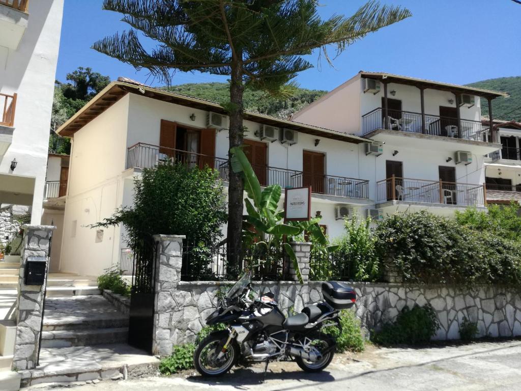 una motocicleta estacionada frente a un edificio en Mario Rooms, en Vasiliki