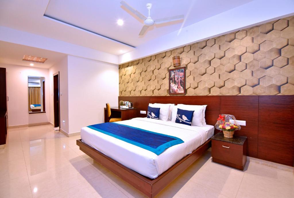 a bedroom with a large bed and a stone wall at I V Sanctum Hotel in Bengaluru