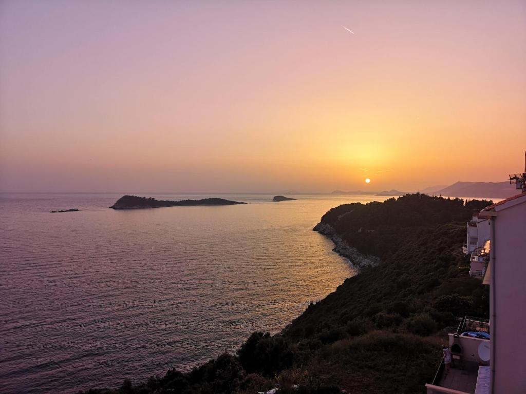 a sunset over a body of water at Sea Sky Apartment in Cavtat