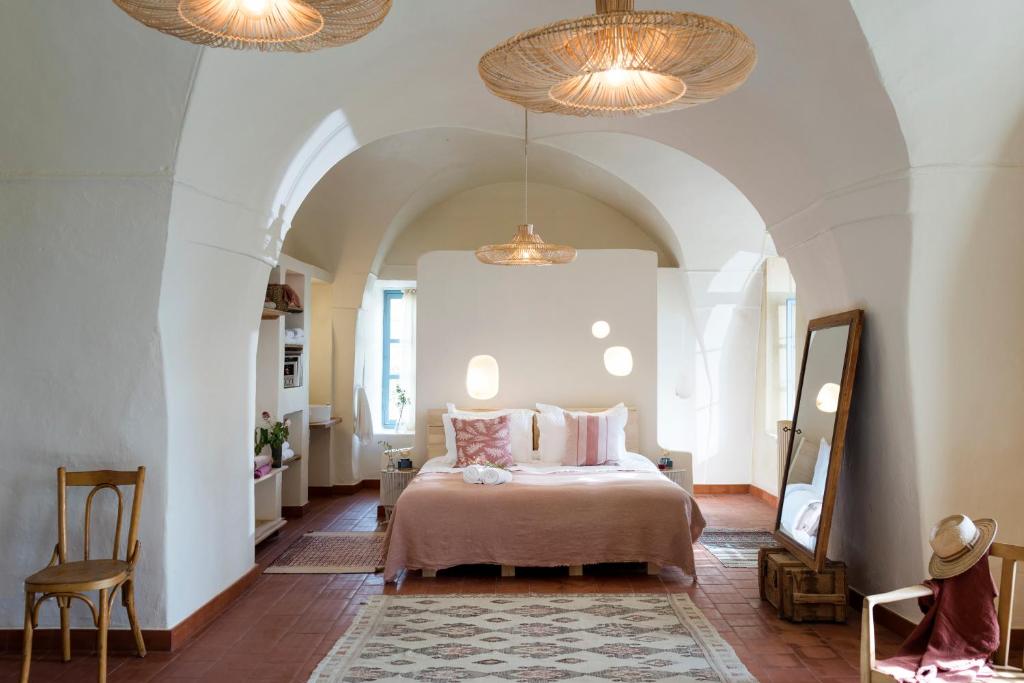 a bedroom with a bed and two chandeliers at La Maison des Sources in ‘Ayn Zḩaltā