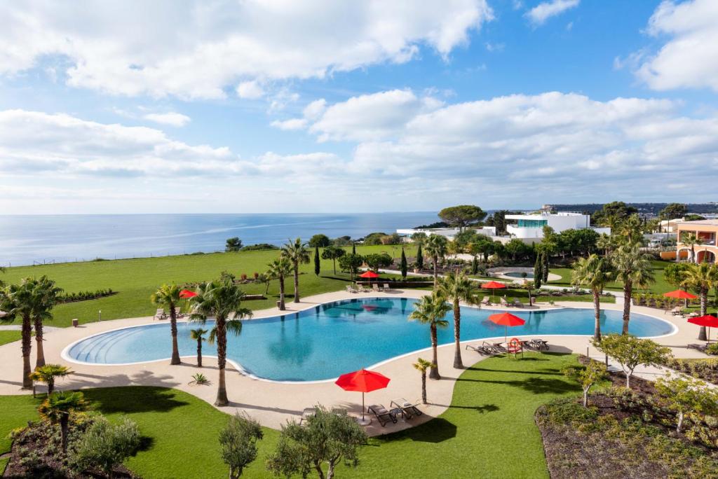 una vista aérea de una piscina con palmeras y el océano en Cascade Wellness Resort, en Lagos