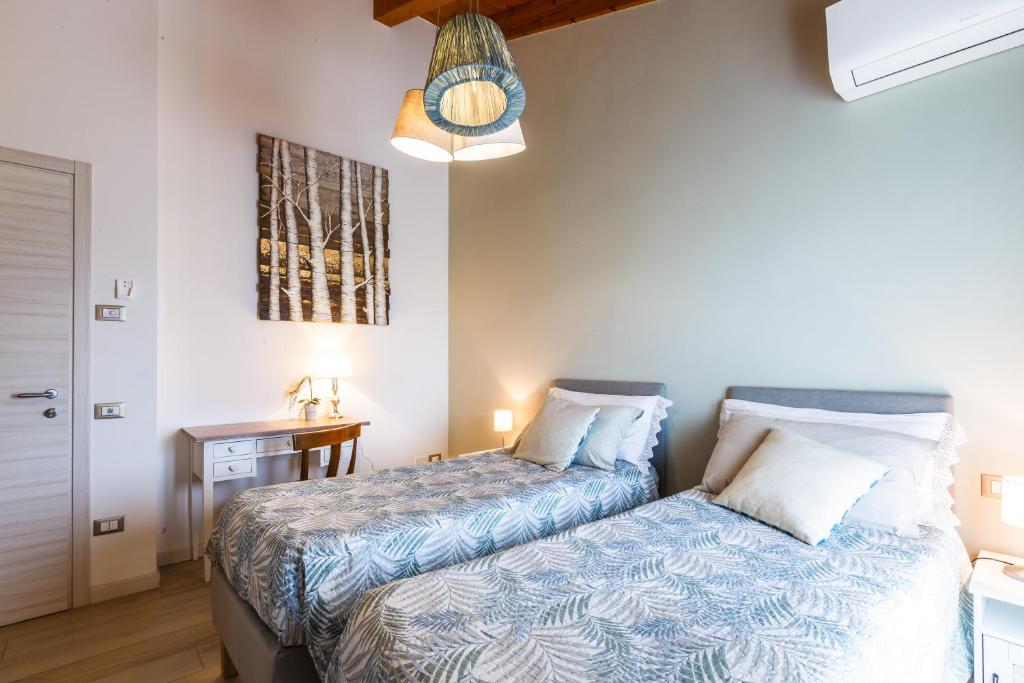 um quarto com 2 camas e uma mesa com um candeeiro em B&B ARMONIE DI CAMPAGNA em Galliera Veneta