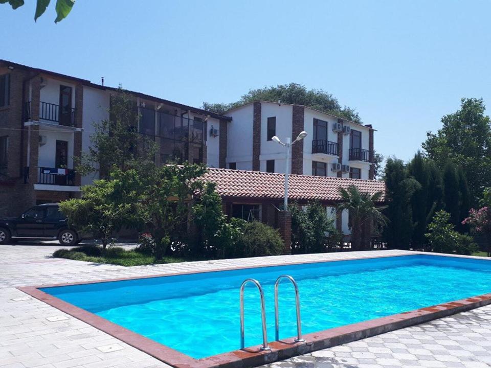 a swimming pool in front of a building at Shaloshvili's Cellar Hotel in Shilda