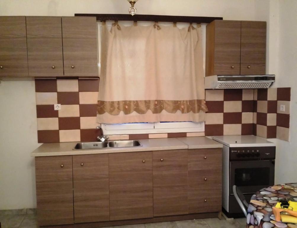 a kitchen with a window and a sink and a stove at Paradise City studios in Loutraki