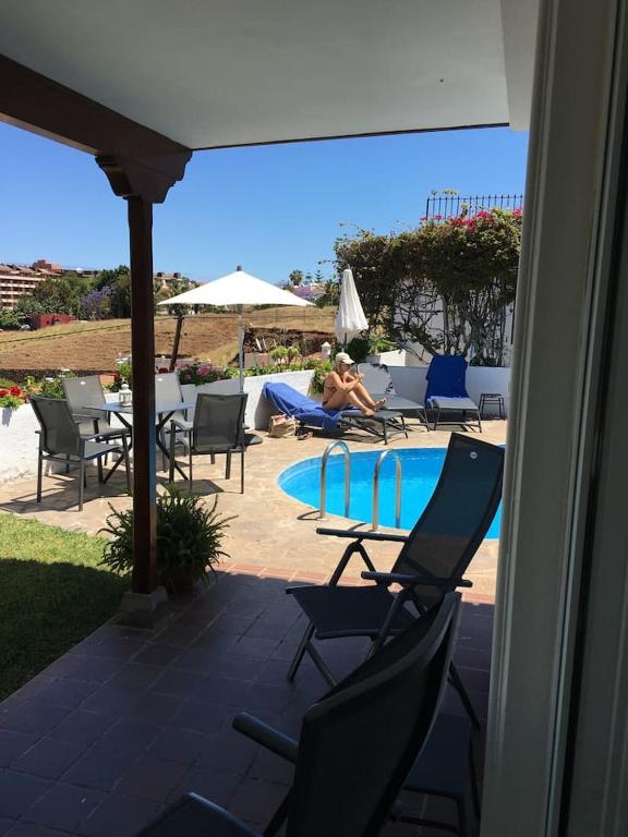 osoba siedząca na krześle obok basenu w obiekcie Casa Janni with heated private pool w Puerto de la Cruz