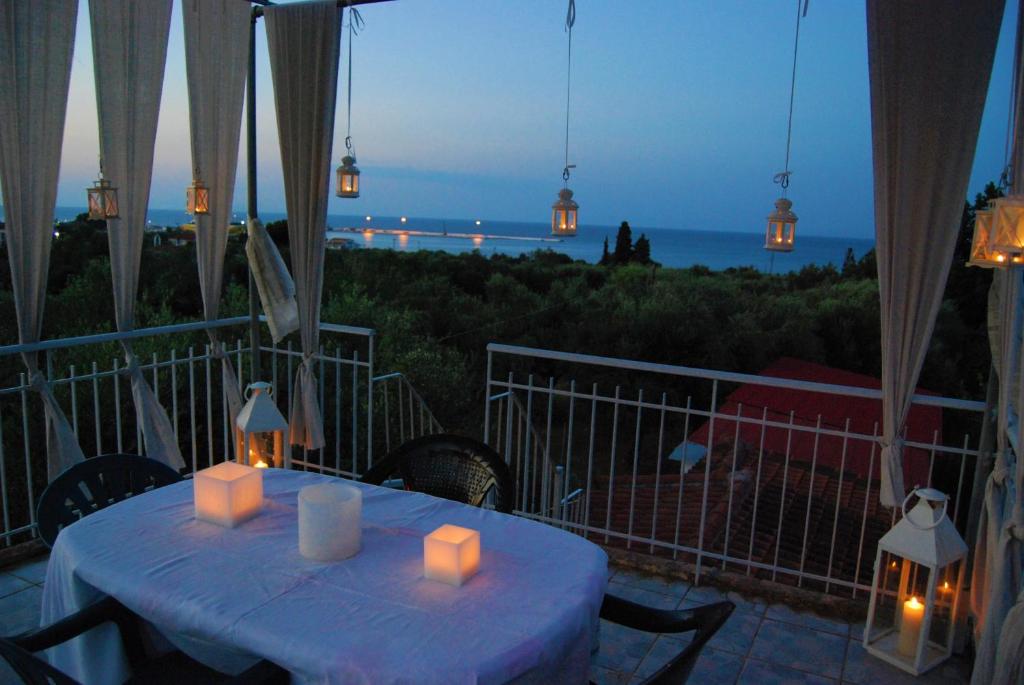 einen Tisch mit Kerzen auf einem Balkon mit Meerblick in der Unterkunft TRADITIONAL ROOM the small museum IONIAN SEA in Kyllini
