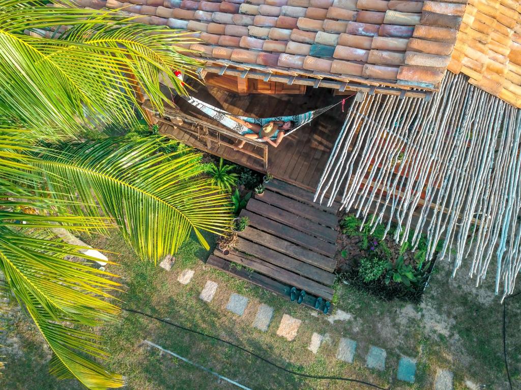 an overhead view of a house with a bench and palm trees at Convento Arcádia in Atins