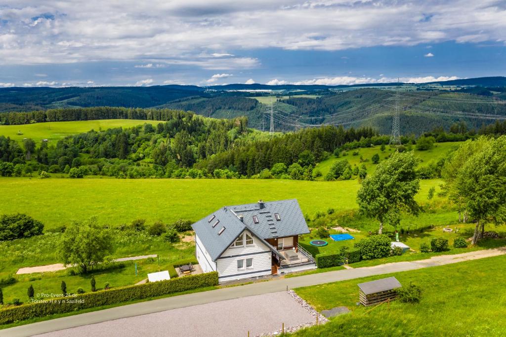 una vista aérea de una casa en un campo verde en Ferienwohnung Falkenblick OG im FH Falkenhöhe en Meuselbach-Schwarzmühle