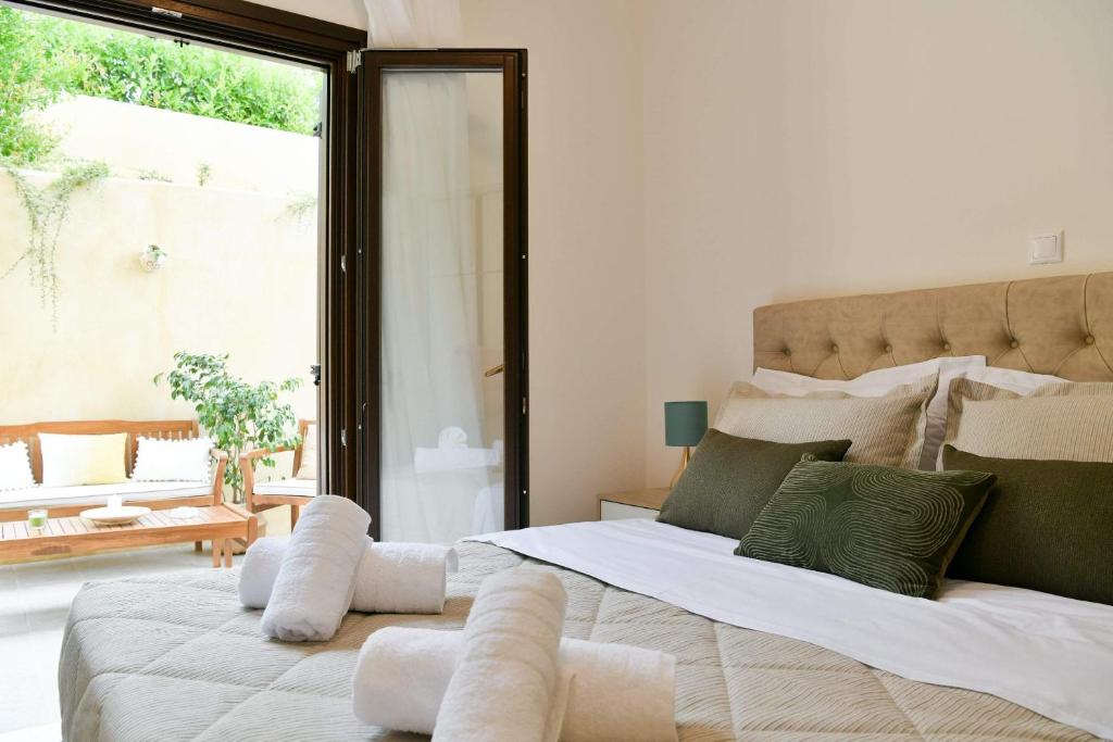 a bedroom with a large bed with a large window at Anemi Deluxe Apartment in Kolios