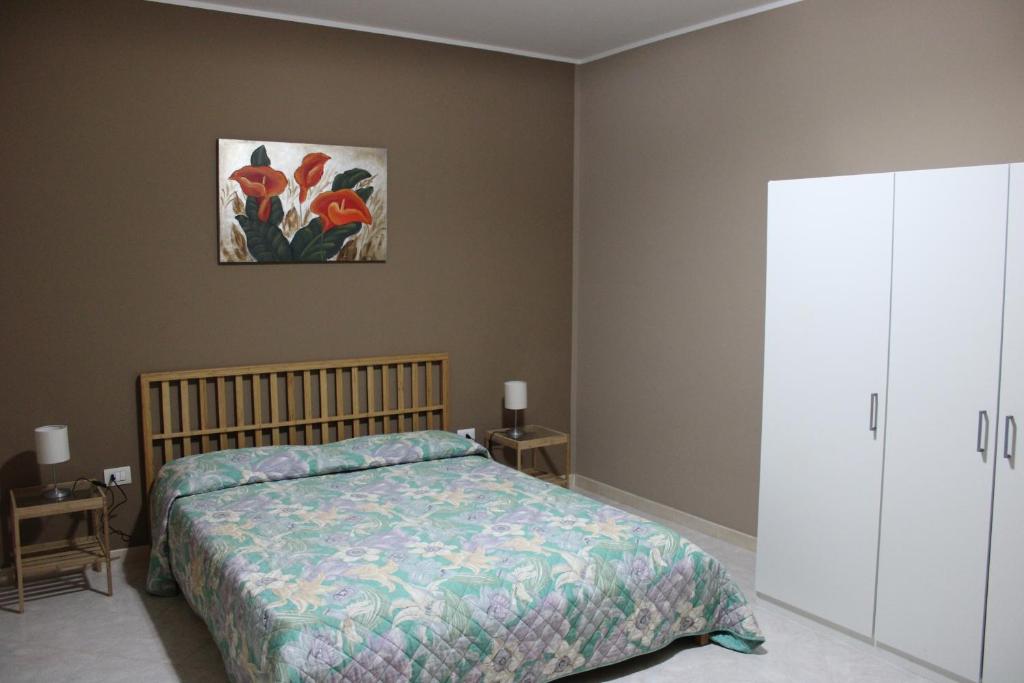 een slaapkamer met een bed en een schilderij aan de muur bij Appartamento Canottieri in Marsala