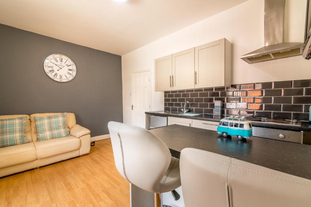 cocina con mesa y reloj en la pared en PLATFORM Avenues Apartment 2 en Hull