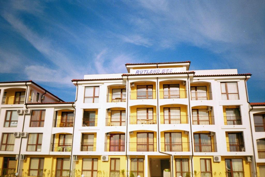 un edificio bianco con un cartello sopra di Apartment Rutland Beach a Ravda
