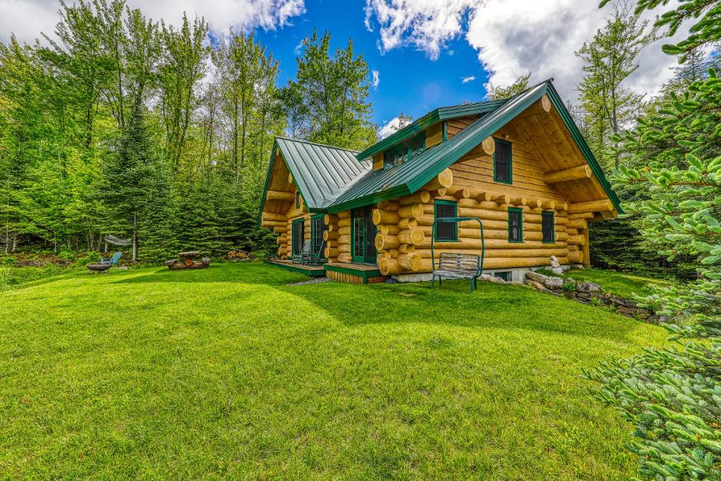 a log cabin in the woods with a yard at Eaglet Log Home in Franconia