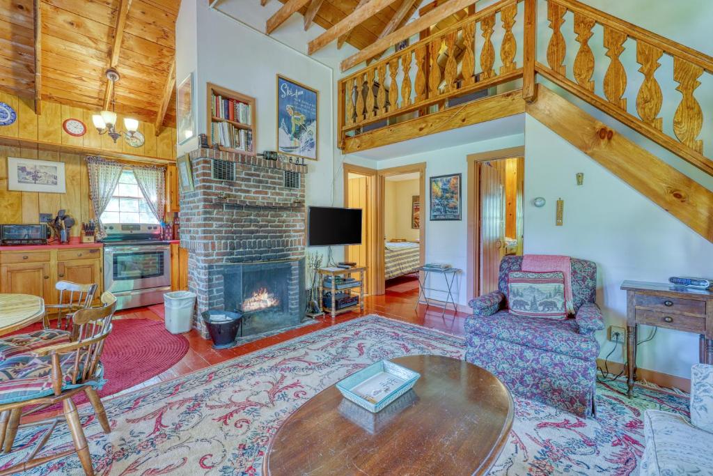 a living room with a table and a fireplace at Emmon's Mittersill Village Chalet in Franconia
