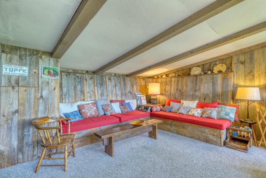 - un salon avec un canapé rouge et des murs en bois dans l'établissement The Tupfe Cabin, à Franconia