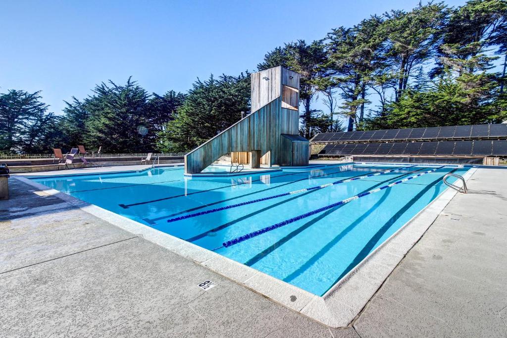 a large swimming pool with a building behind it at Cabin 55 in Sea Ranch