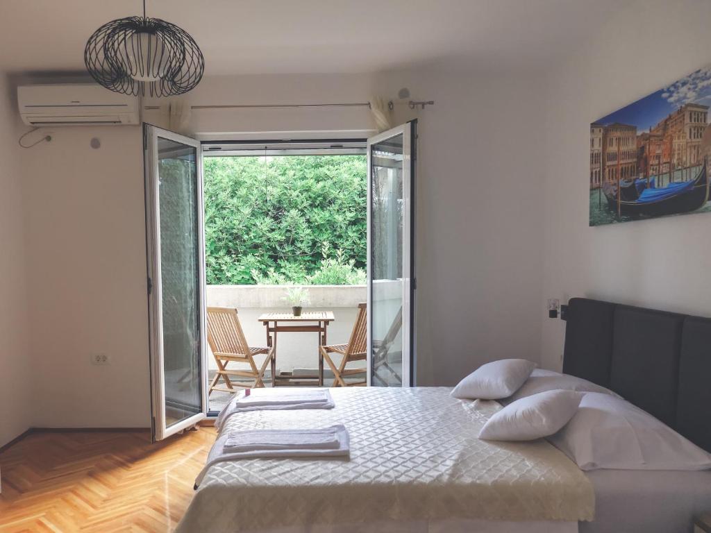 - une chambre avec un lit, une table et une fenêtre dans l'établissement Apartment LIM, à Budva
