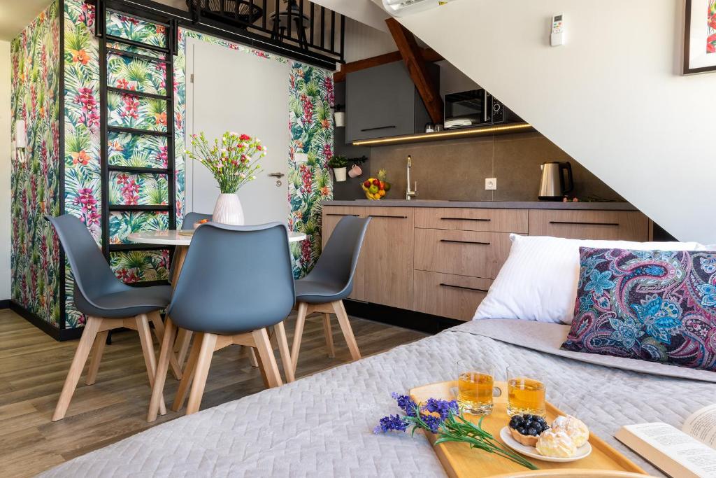 um quarto com uma cama e cadeiras e uma cozinha em Apartamenty Wrocław em Breslávia