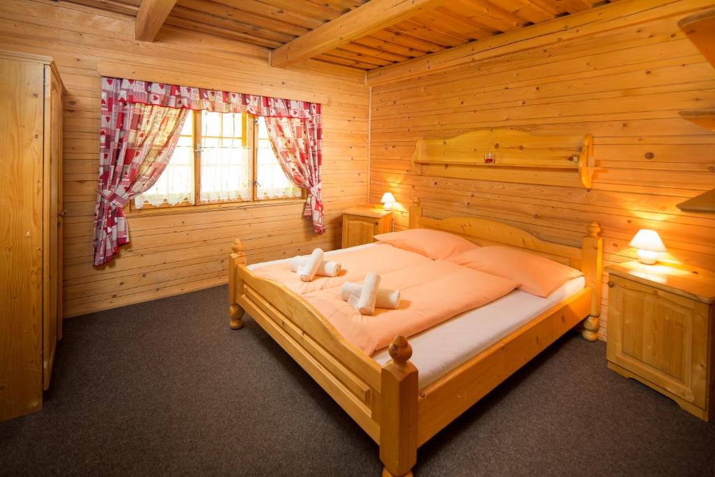 una camera con un letto in una baita di tronchi di Apartmány Kubínska hoľa a Dolný Kubín