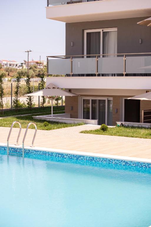 a building with a swimming pool in front of a building at Astra Sarti Luxury Suites in Sarti
