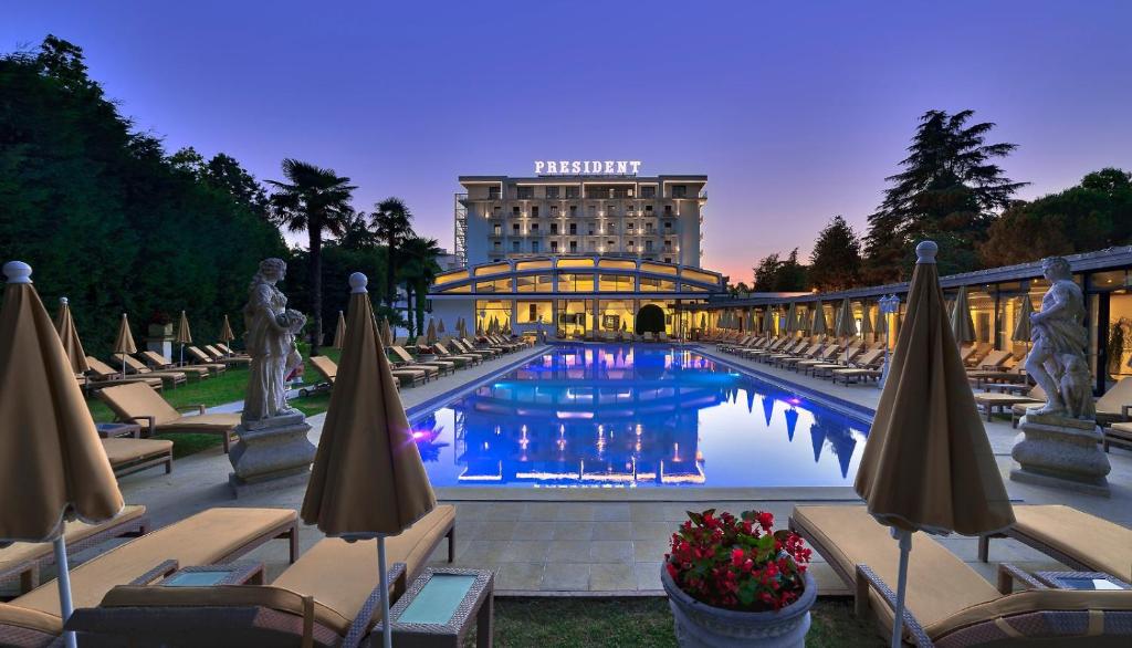 a hotel with a swimming pool in front of a building at Hotel President Terme in Abano Terme